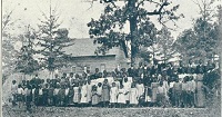 children standing in front of a school house